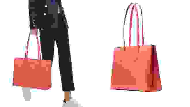 Woman carrying coral colored tote
