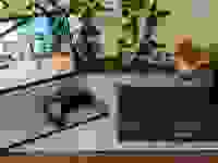 An open Lenovo IdeaPad Gaming Chromebook next to a closed laptop with an Xbox controller resting atop its keypad.