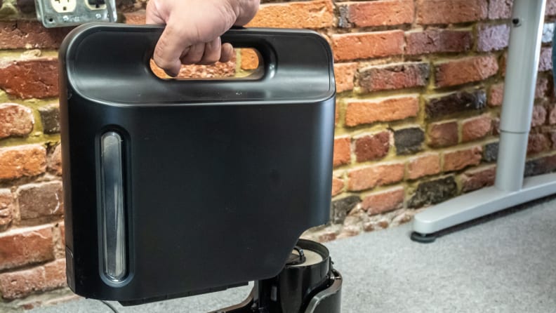 Empty the Shark IQ R101AE bin right into the trash.