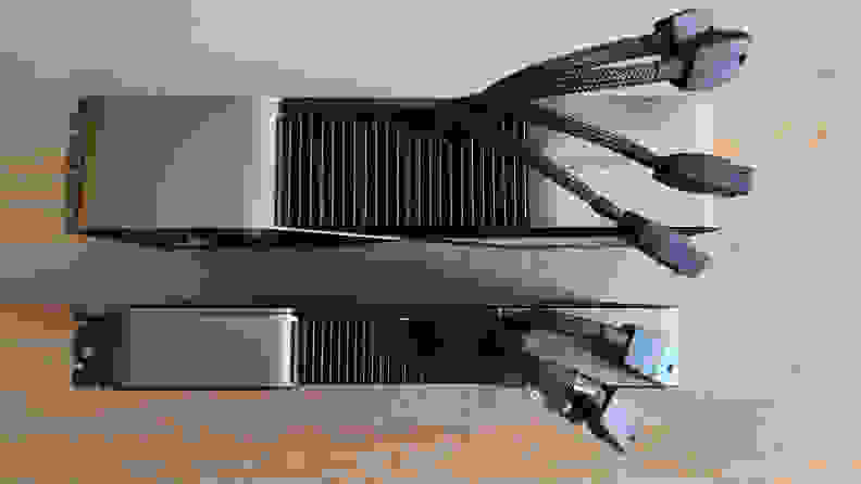 Two graphics cards standing upright side by side with cables coming out of the top.