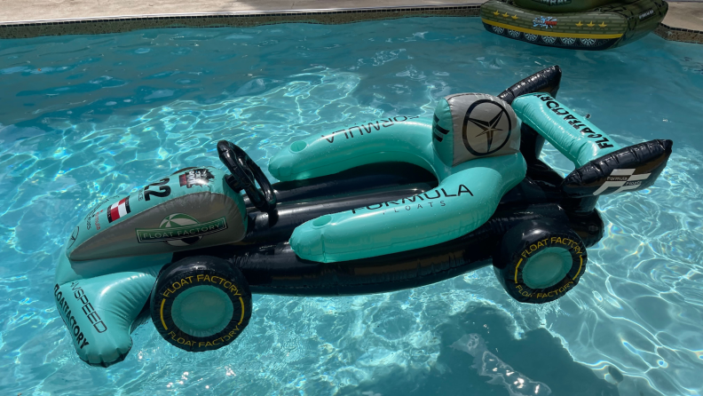 Racecar themed inflatable pool toy in water.