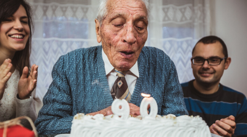 Man blowing out birthday candles on cake