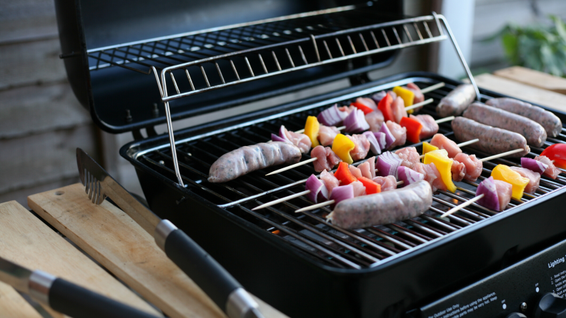 Skewers and sausages cooking on an open grill