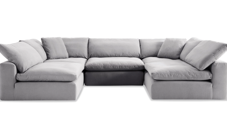 A grey fluffy sectional on a white background.