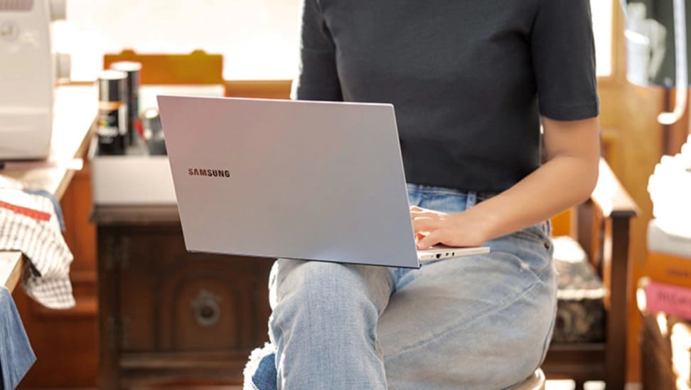 Person balancing laptop on lap while typing.