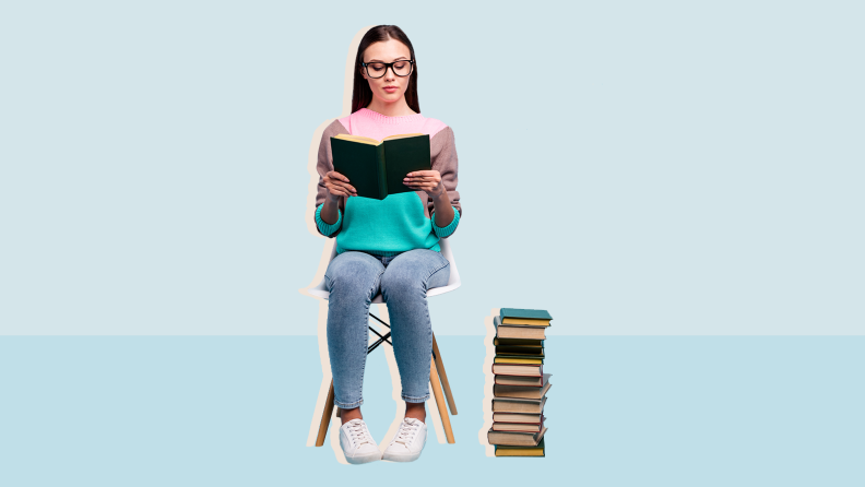 Girl sitting in chair reading a book and a stack of books next to her on blue background