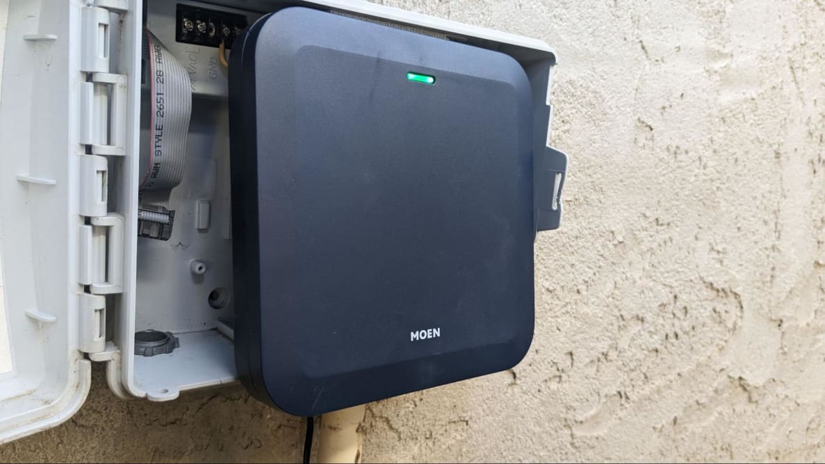 Moen Smart Sprinkler Controller attached to control box on exterior wall.