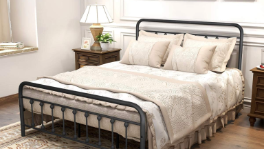 Photo of a rustic Dumee platform bed set up in a bedroom with a lamp beside it.