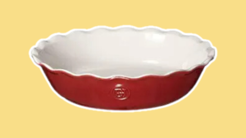 The Emile Henry 9" Pie Dish in the colors red and white on a yellow background.