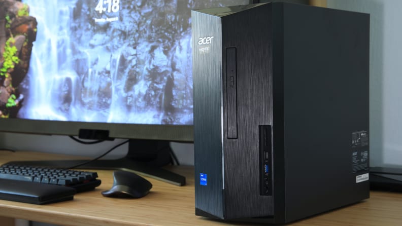 A black Acer desktop computer tower sits on the desk next to the computer monitor.