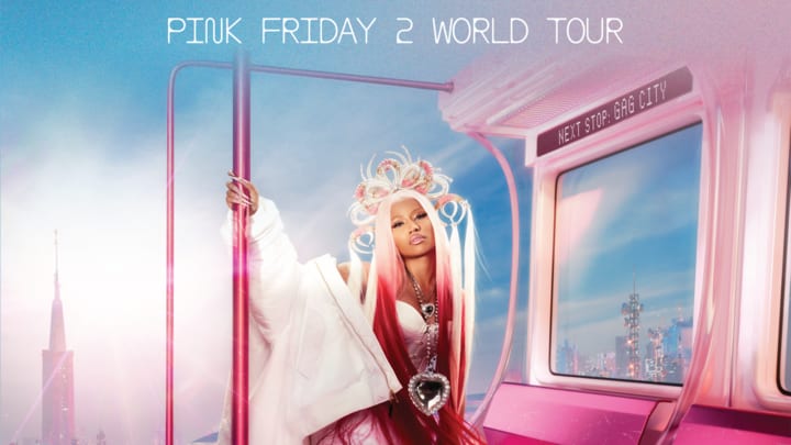 Nicki Minaj is pictured in a pink subway car, crossing through a blue city sky