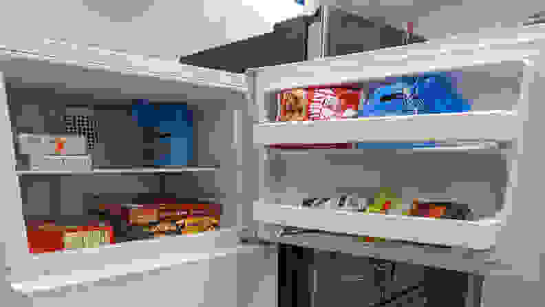 A close-up of the freezer compartment and its door bins, all stocked with food.