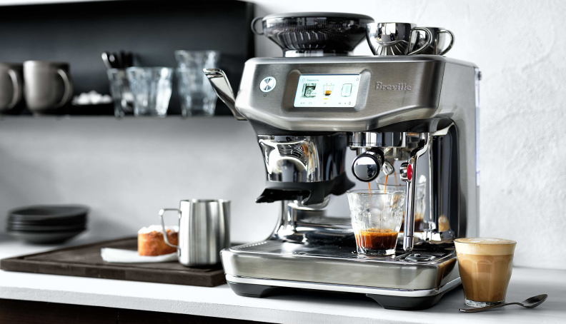Breville Barista Touch Impress machine surrounded by espresso crafted beverages on a countrtop