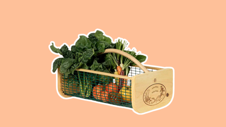 Assorted vegetables are arranged in the Gardener's Harvest Basket, made wood and wire.