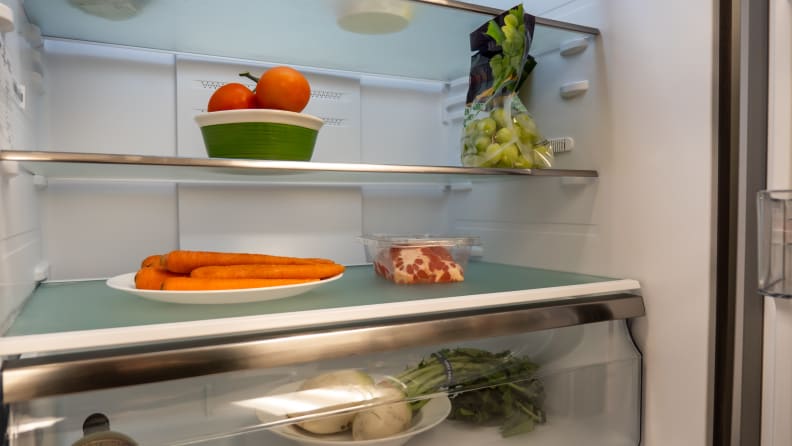 A shot of the fridge's interior, focusing on its interior wall, specifically the large gap between some of the shelf slots.