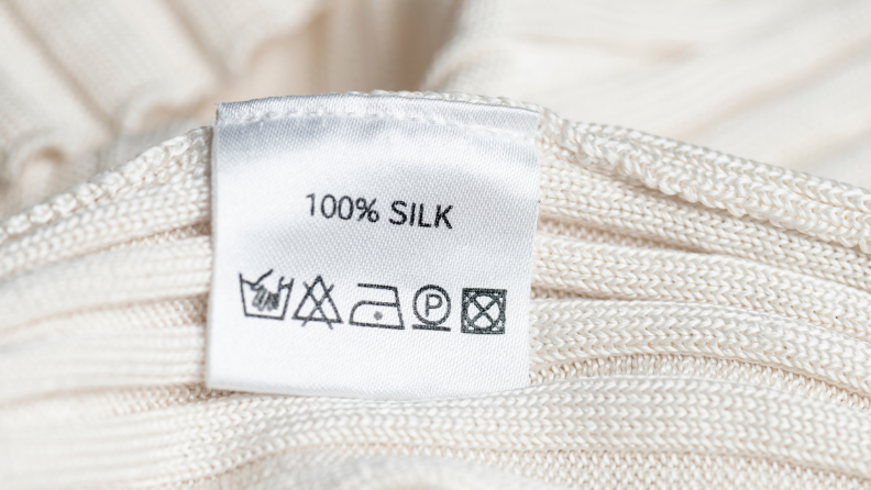 White clothing with a tag that reads 'silk' with other care symbols