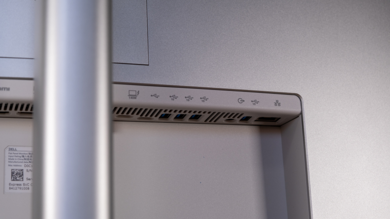 Close-up of the back of a Dell monitor, showing multiple USB ports, an Ethernet port, and power input labels.