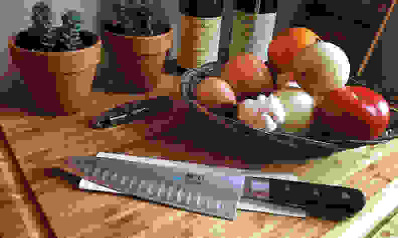 A knife sitting on a table next to some fruit.