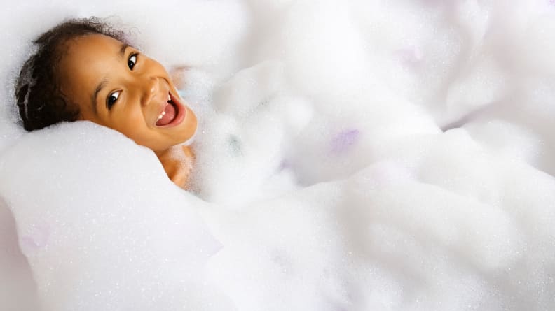 A little girl in a tub full of bubbles
