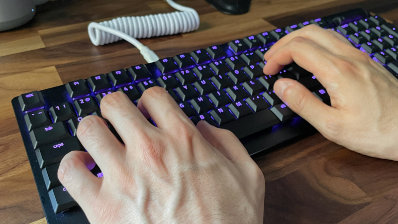 A person types on a gaming keyboard.