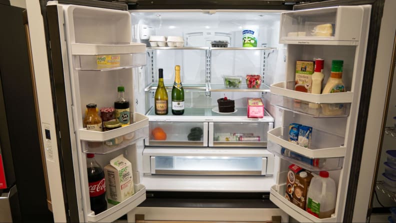 Open fridge with food and condiments inside.