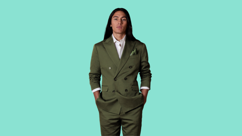 A model wearing a double-breasted green suit.