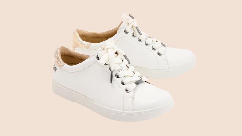 white leather sneakers on beige background