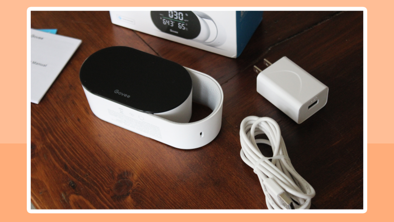 The Govee Smart Air Quality Monitor and its contents next to its retail box.