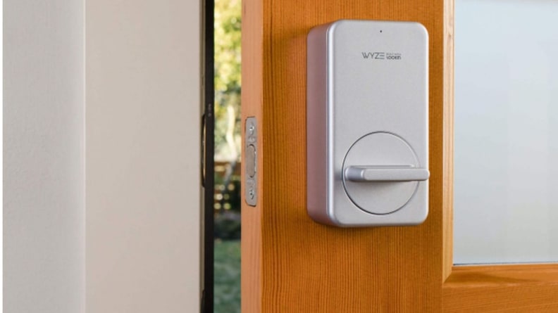 Serrure intelligente argentée attachée à une porte fissurée dans la maison.