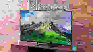 A Sony Bravia 9 Mini-LED TV sitting on a wood entertainment center, with a picture of a mountain on the screen.