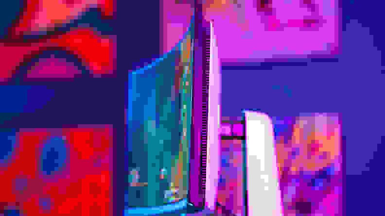 A monitor on top of a desk with a colored background