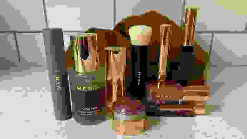 An array of makeup products standing up on a speckled countertop.