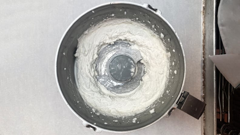 A top-down photo of a food processor filled with whipped feta.