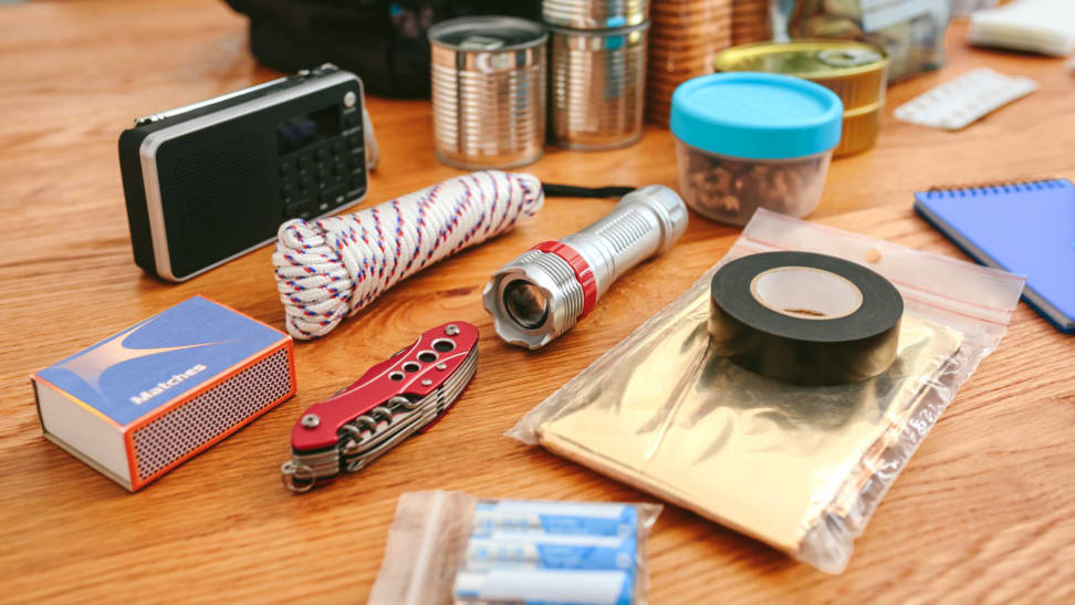 Emergency preparedness kit with emergency blanket spread out on table.