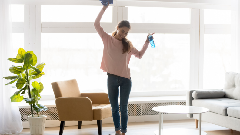 Woman dancing with cleaning supplies