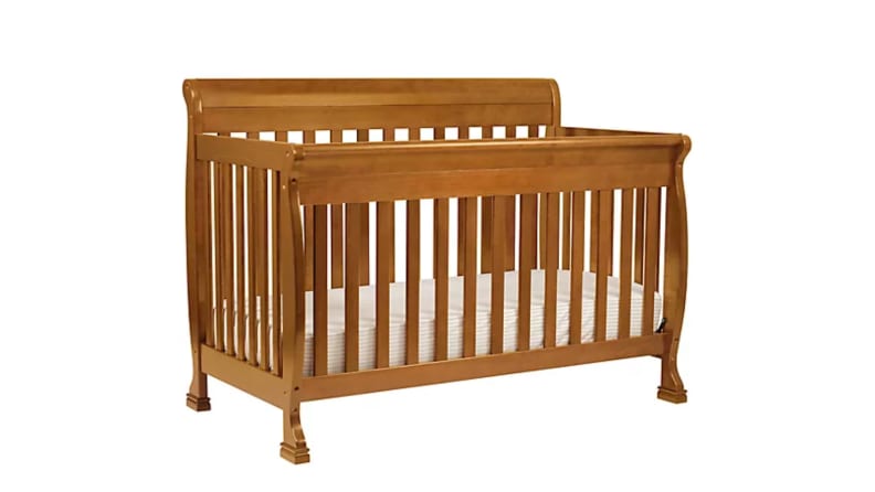 An image of a wooden crib seen at a slight side angle.