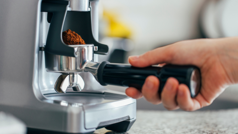 A person prepares to pull an espresso shot using an espresso machine.