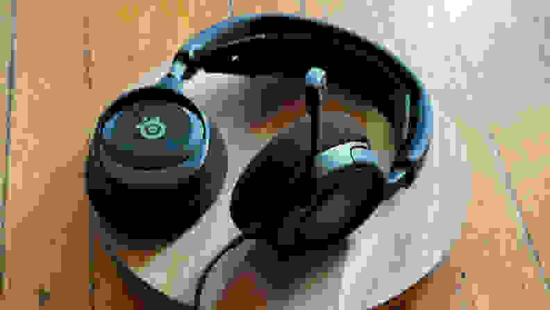 A pair of gaming headphones with a mic arm on a wooden platform