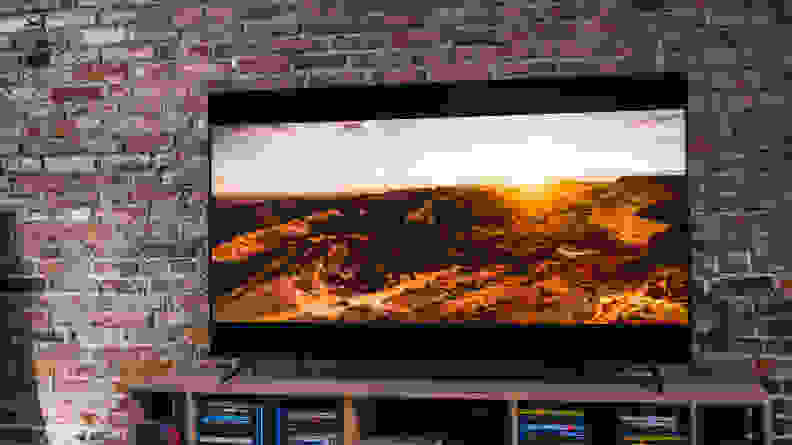 A photograph of the Vizio smart TV shows the screen's rich color output. There's a rocky, sun-bathed landscape on the television.