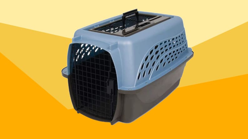 A blue and black pet carrier against a varied yellow background.