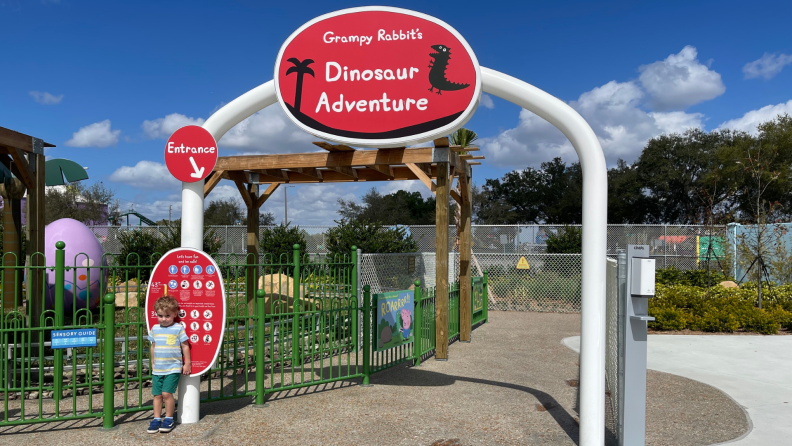 A child standing outside of a ride at Peppa Pig's Florida theme park.