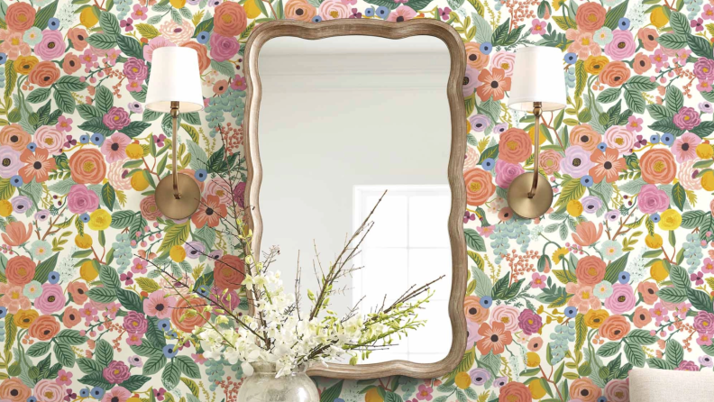 Multi-colored floral peel-and-stick wallpaper on wall in home behind mirror.