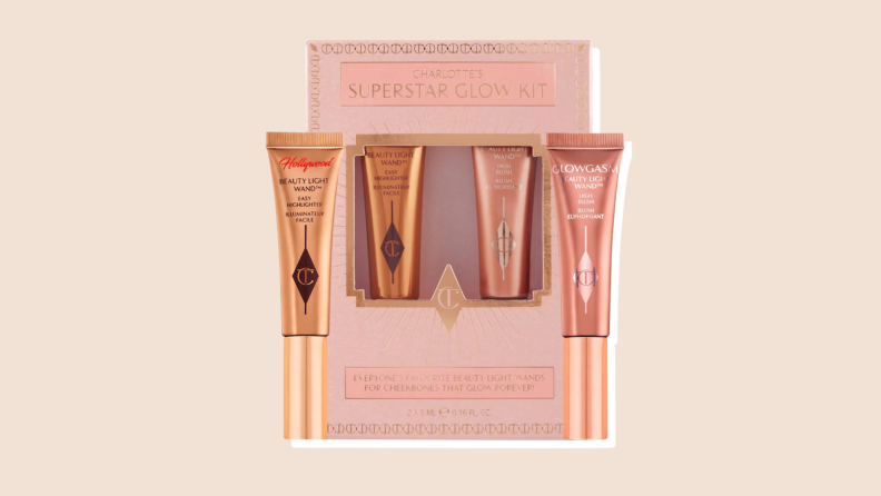 Two bronze and rose gold products sit inside a pink Charlotte's Superstar Glow Kit box against a neutral background.