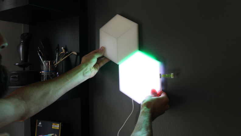 Person installing Govee hexagon lights on wall.