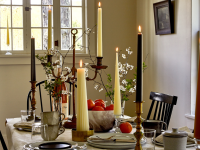A variety of tall candles on a dining room table