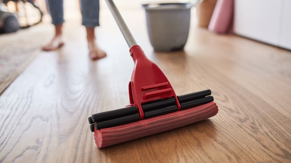 Woman cleaning a floor with a mop and bucket