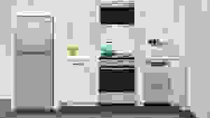A small kitchen with a refrigerator, an oven range, utensils on the countertop, and so on.