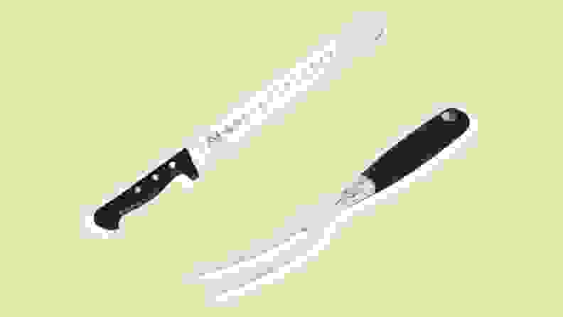 An electric carving knife and fork on a beige background.
