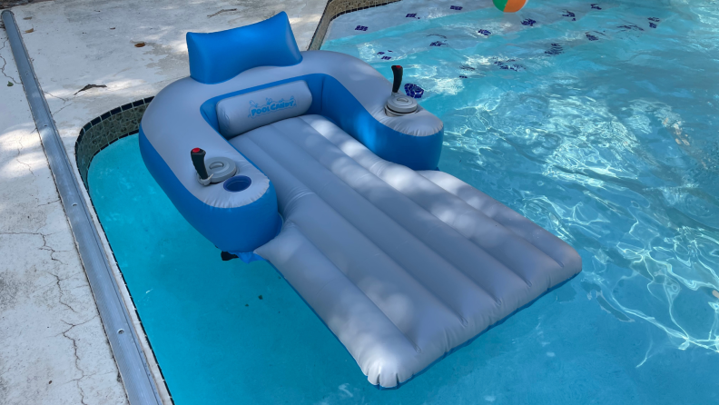 Sharper Image Motorized Pool Lounger floating on top of pool water outdoors.