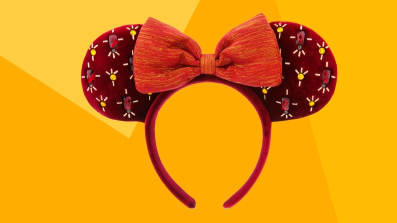 An image of red sequined Mickey Mouse ears on a yellow background.